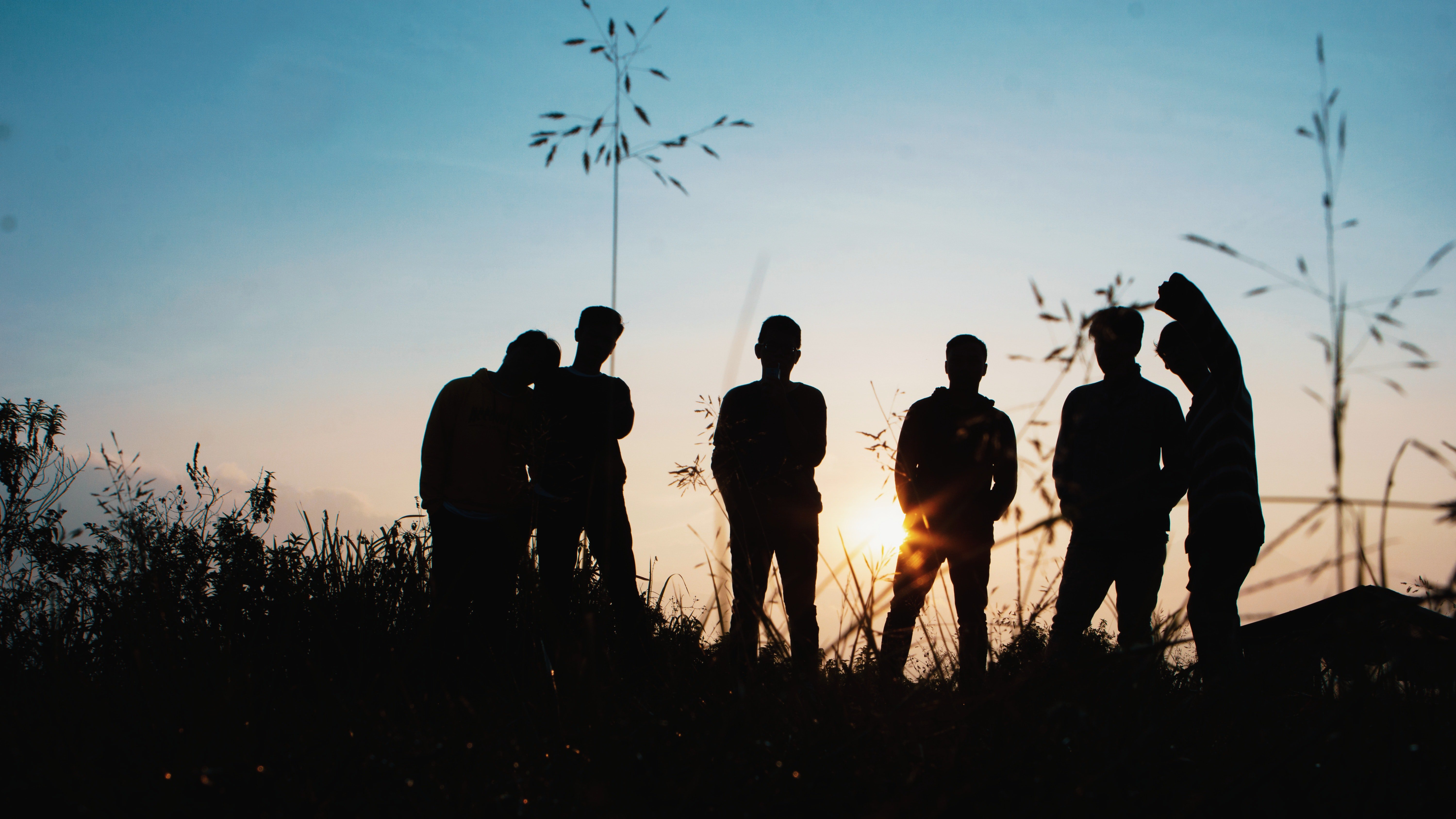 silhouette-group-of-people-standing-on-grass-field-1250346.jpg